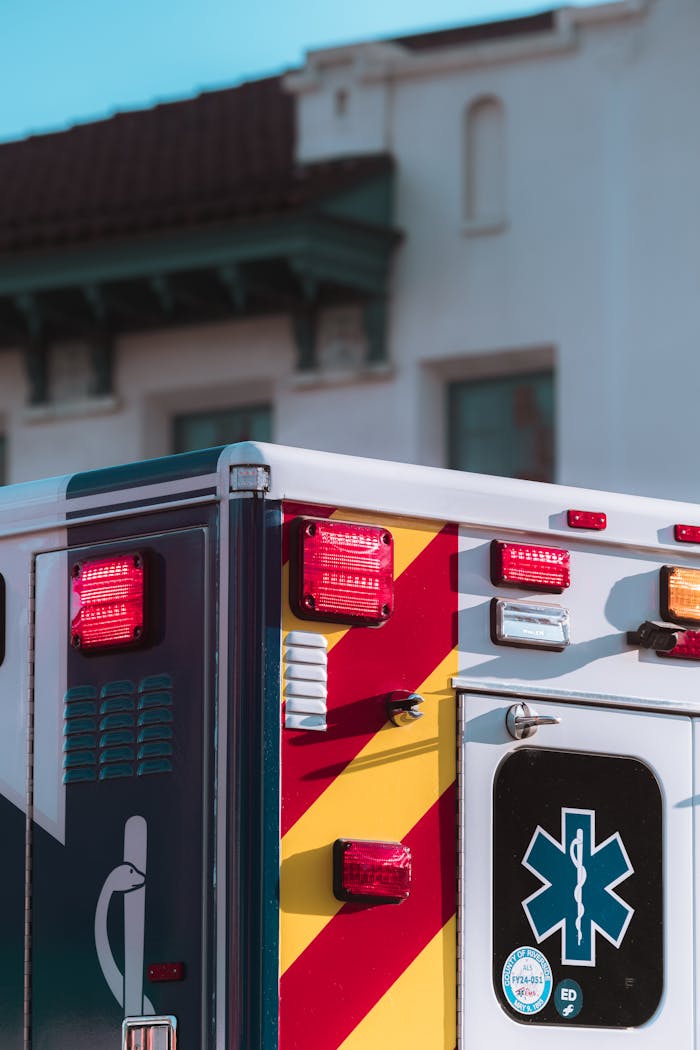 Close-up of an ambulance with emergency lights on in a city environment, conveying urgency and response.