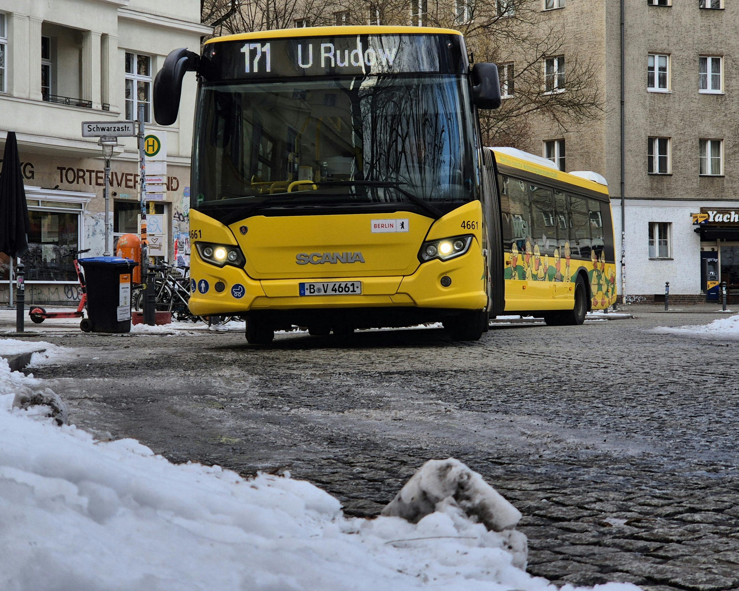 Yellow Berlin city bus in snowy urban winter scene.