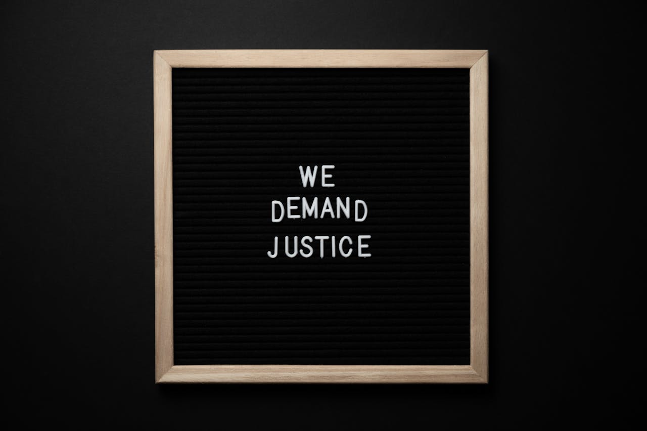 From above wooden frame with we demand justice text placed on black table