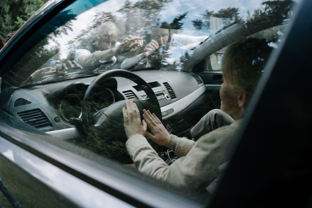 pexels-photo-5435427-5435427 Intense moment of zombies attacking a car windshield in a suspenseful setting.